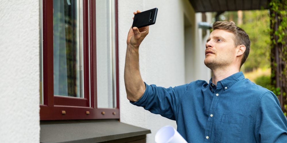 Real Estate Appraiser Taking Pictures Of Property With Phone