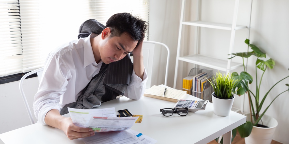 Sad Confused And Stressed Of Young Asian Man Holding Bills Letter Of Credit Card Debt