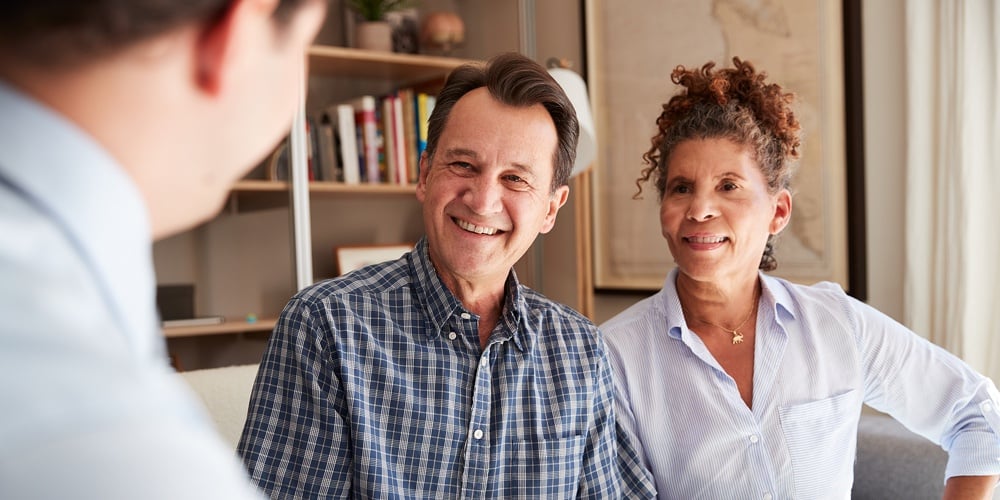 Senior Couple Meeting With Male Financial Advisor At Home