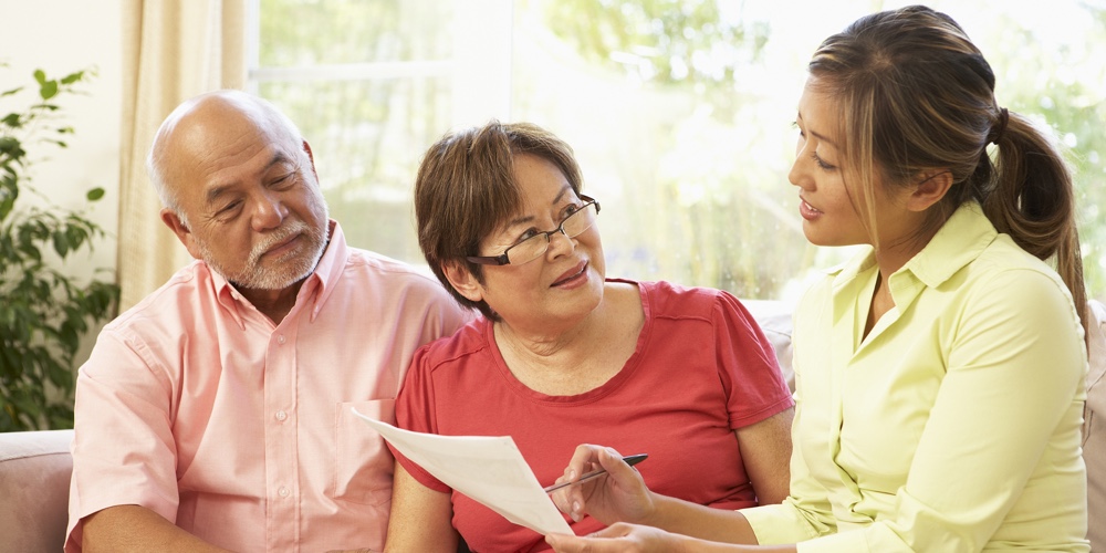 Senior Couple Talking To Financial Advisor At Home