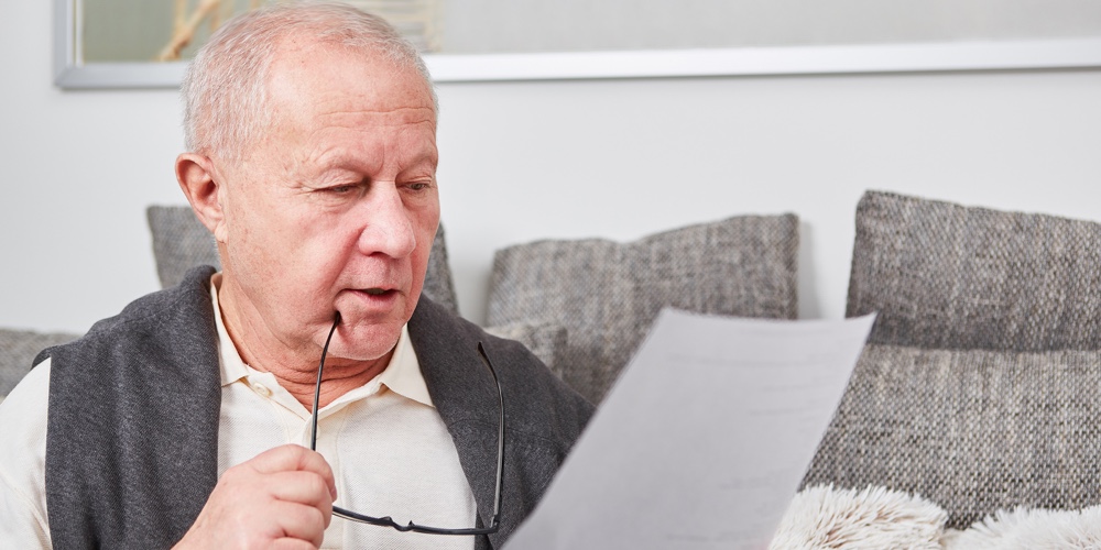 Senior as retiree holds document for finance documentation