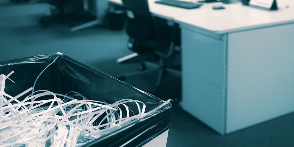 Shredded Paper In A Bin With Blurred Open Space Modern Office In Background – Documents Destroyed By