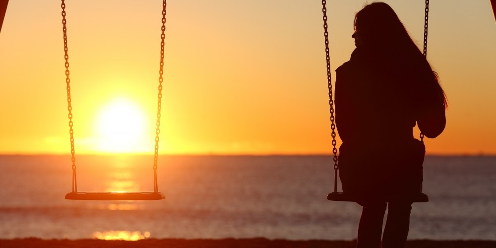 Single Woman Alone Swinging On The Beach