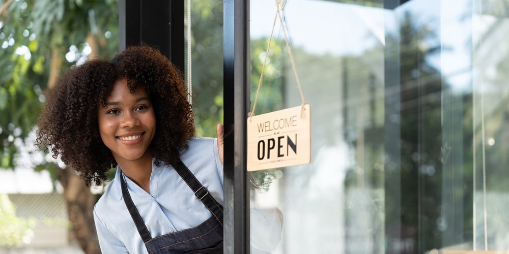 Small Business African Female Owner Smiling While Turning Sign For Opening Of Cafe. Happy Afro-ameri