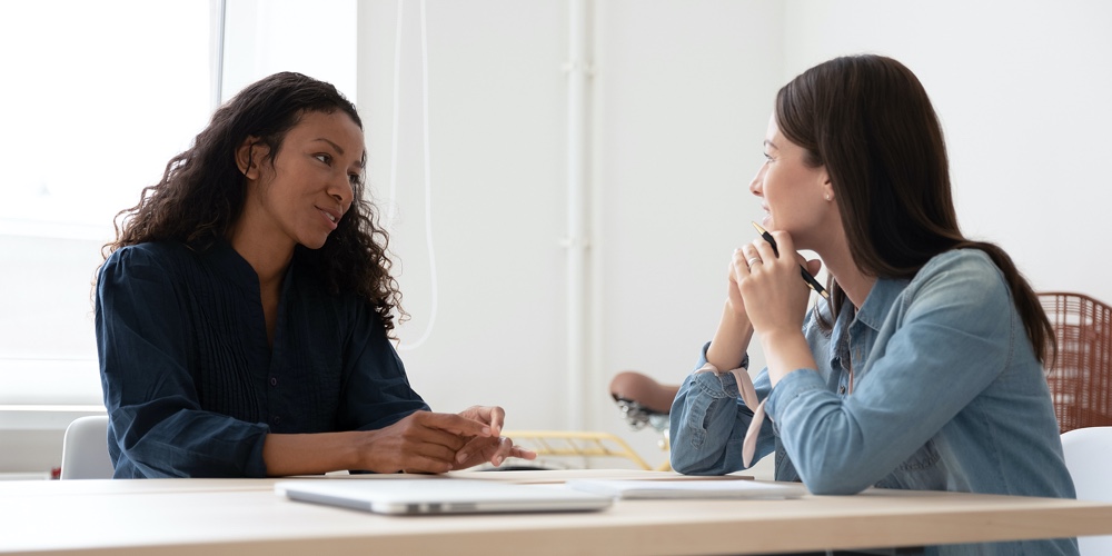 Smiling Female Employer Consider Job Candidate At Interview