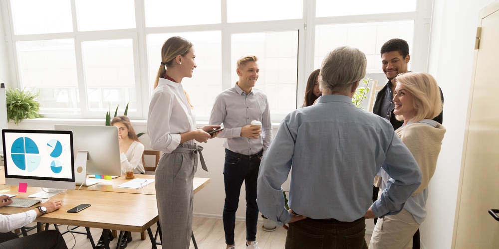 Smiling Happy Young And Senior Multi-ethnic Workers Talking In Coworking