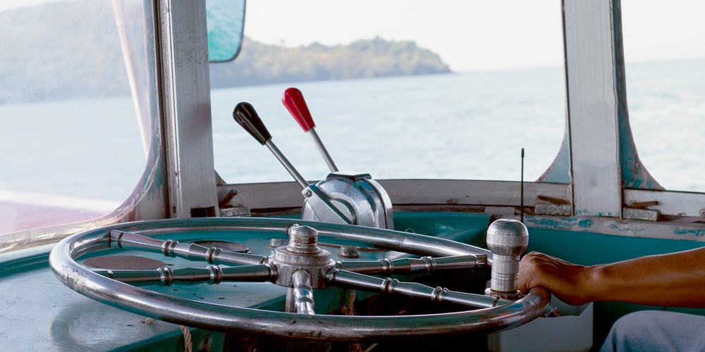 Steering Wheel Ship And Hand Of Boat Driver Inside The Boat