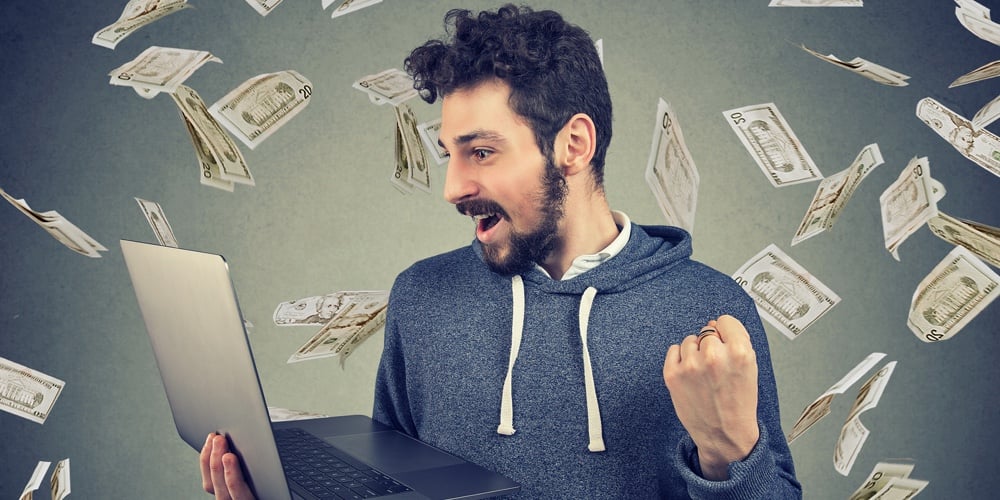 Successful Young Man Using Laptop Building Online Business Making Money Dollar Bills Cash Falling Do