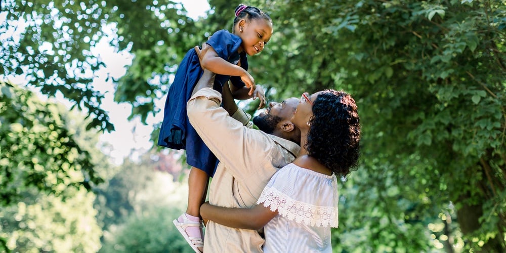 Summer Shot Of Happy African Family Playing In The Park. Family Portrait With Happy People Smiling A