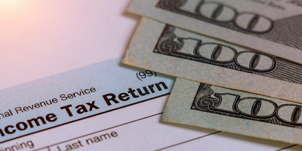 Tax Time – Closeup Of U.s. 1040 Tax Return With 100 Bills Pay Tax
