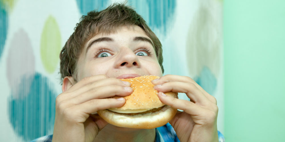 bigstock-Teenager-With-Burger-98640626