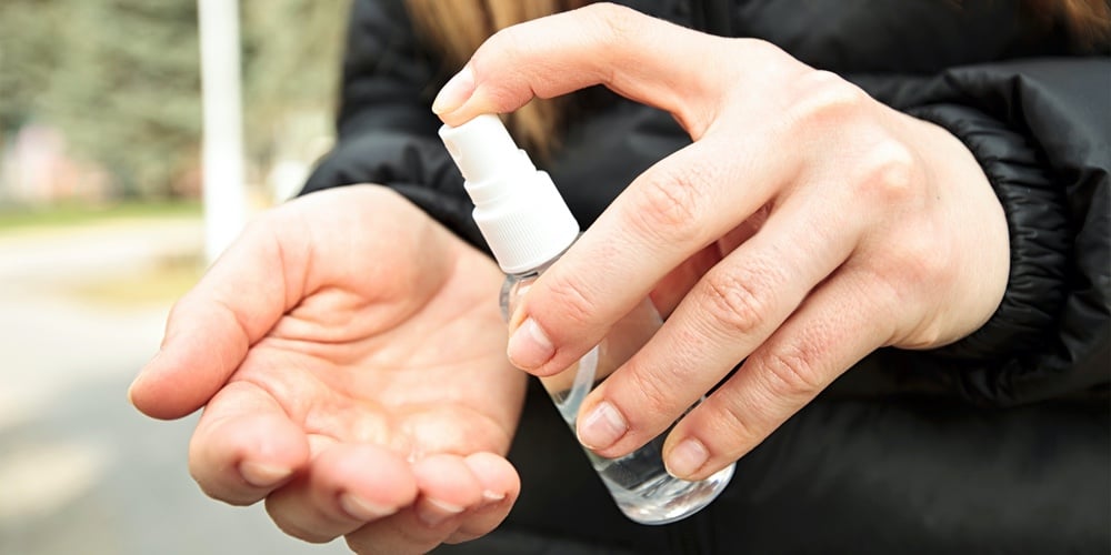 bigstock-The-young-woman-sanitizing-her-356194283