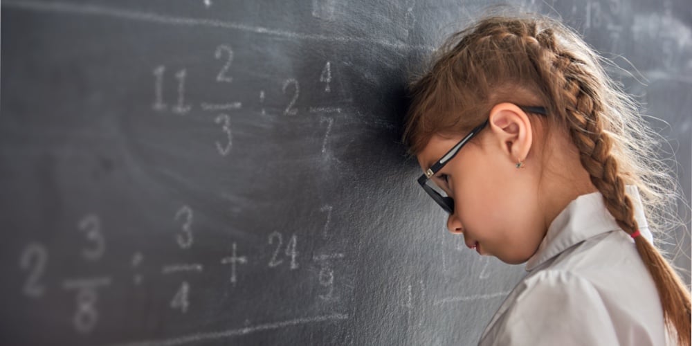 Tough day at school! Sad child near the blackboard indoors. Kid is learning in class. Complex math