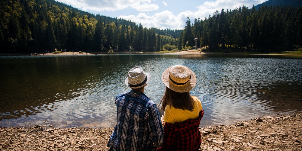 Travelers Couple Admire View Of Mountain Lake. Travel And Active Life Concept. Adventure And Travel
