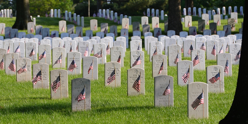 Washington DC / United States – May 25 2014: National flags ant headstones in Arlington National cem