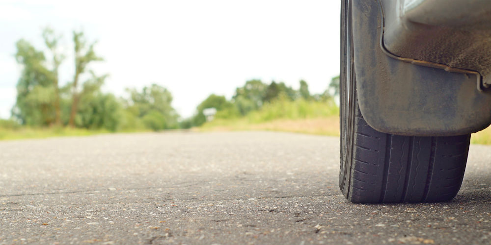 bigstock-Wheel-of-a-car-on-the-road-95865434