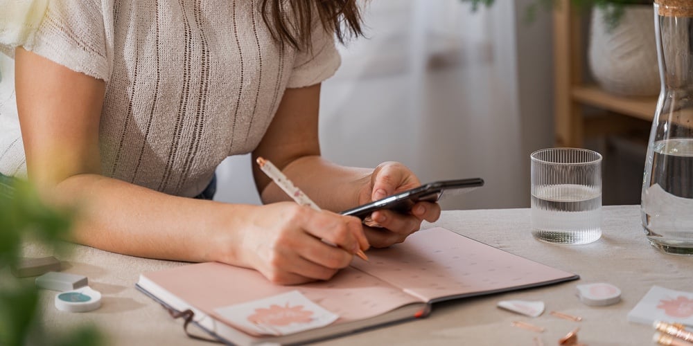 Woman Holding A Cell Phone And Plan Schedule Calendar