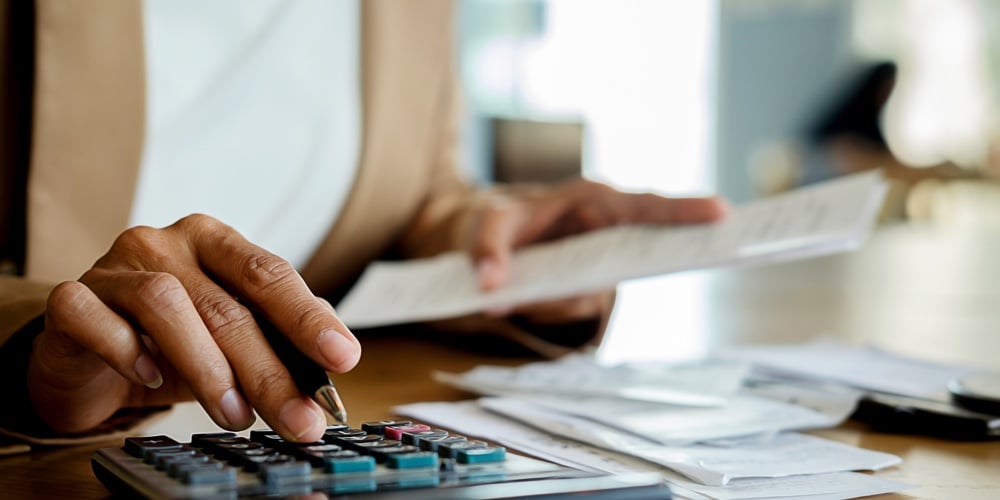 bigstock-Woman-With-Bills-And-Calculato-265210486