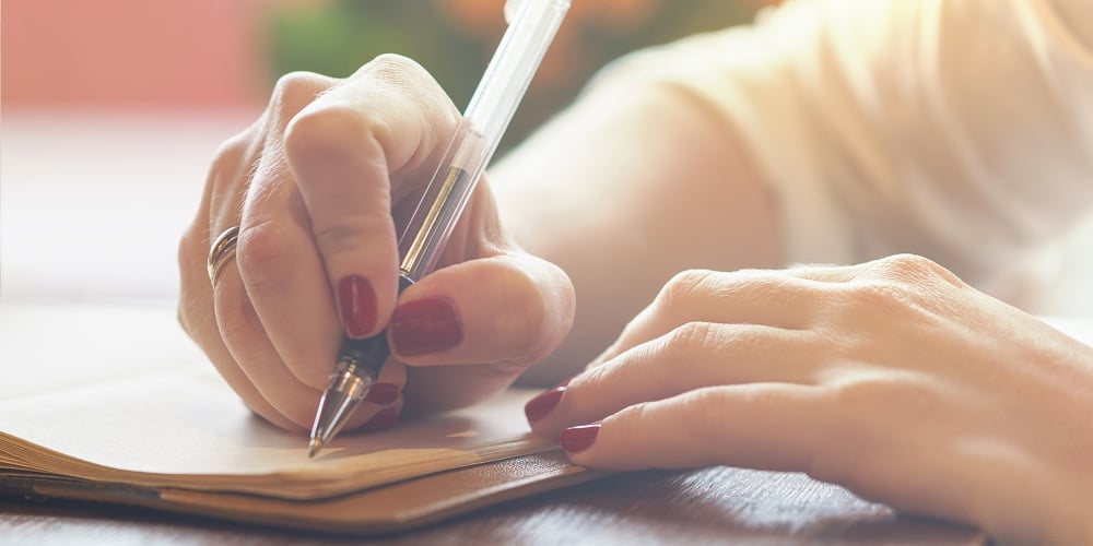 Woman’s Hand With Red Nails Writing Some Message Note Or Letter To Notebook By Pen