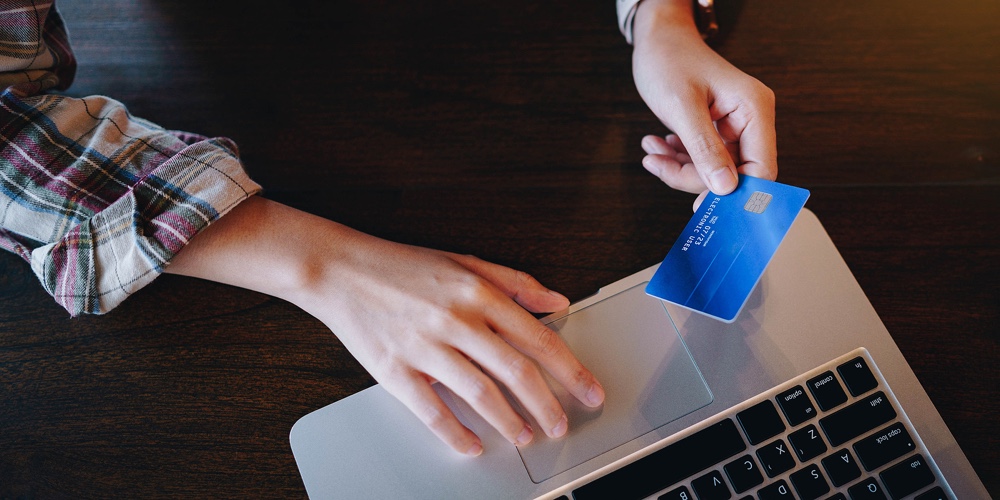 Woman’s Hands Holding Credit Card And Typing On The Keyboard Of Laptop For Shopping Online. Pays For