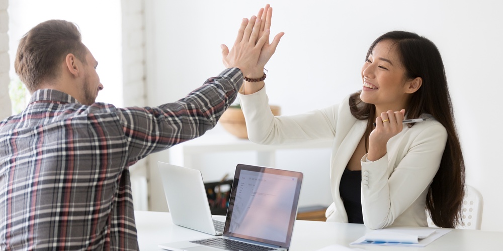 Young Asian And Caucasian Partners Giving High Five At Workplace, Diverse Motivated Colleagues Celeb