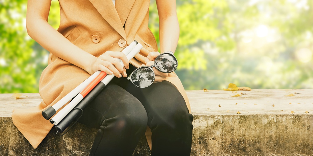 Young Blind Woman With Vision Disabilities Takes  Protects Eyesight And Holds Blind Cane Sitting Cal