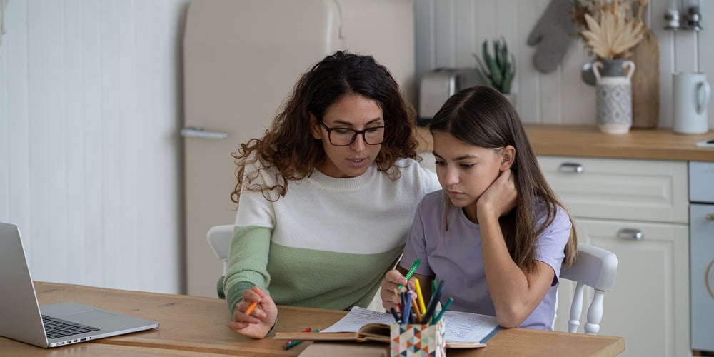 Young Mother Teaching Teen Girl Daughter At Home