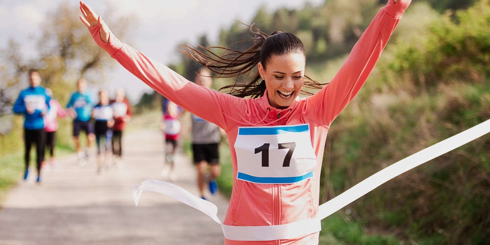 Young Woman Runner Crossing Finish Line In A Race Competition In Nature.