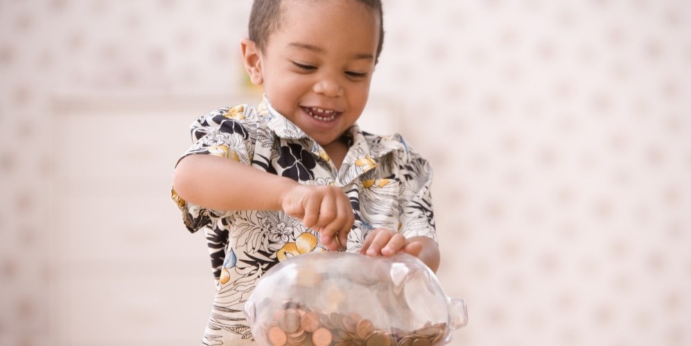 bigstock-Young-boy-putting-money-in-pig-73102693-e1458943484856