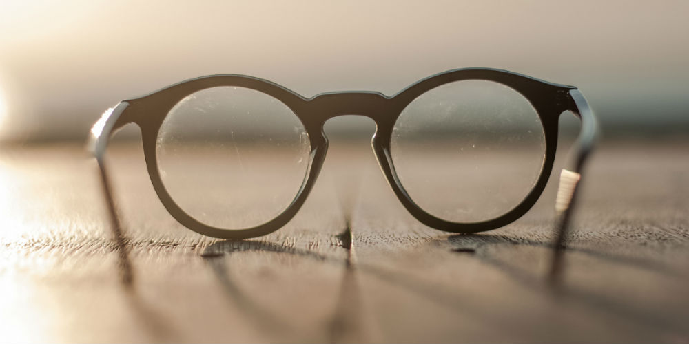 bigstock-glasses-lying-on-a-wooden-tabl-87192227