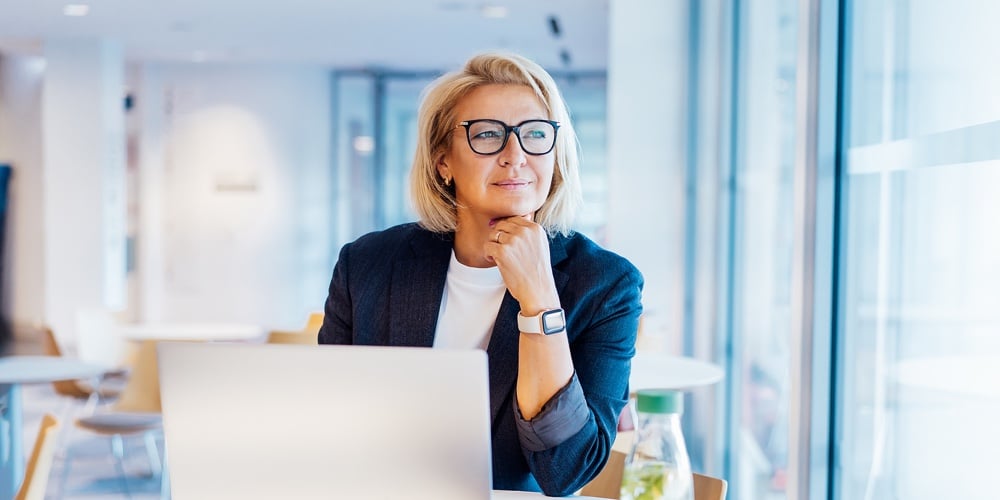 50s Confident Mature Businesswoman Dreamy Looking At Window