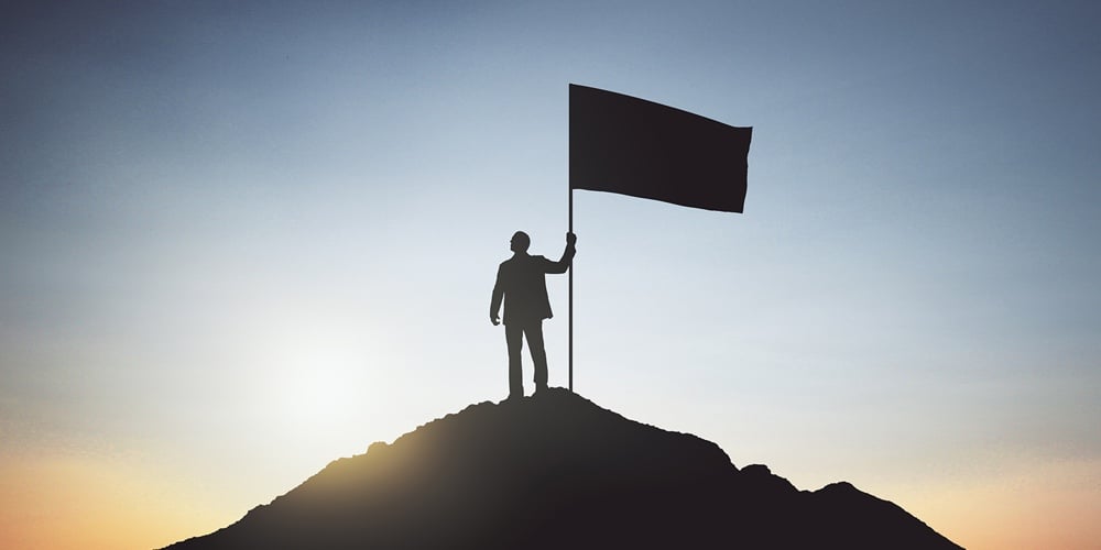 man-on-hill-with-flag-1183801642-1500pixels