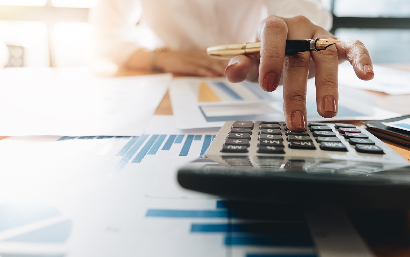 Close Up Business Woman Using Calculator And Laptop For Do Math Finance On Wooden Desk In Office And
