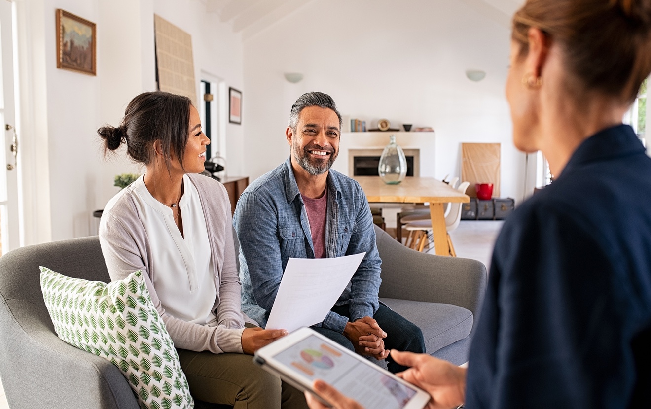 Happy mature couple discussing investments with financial broker during meeting at home. Middle east