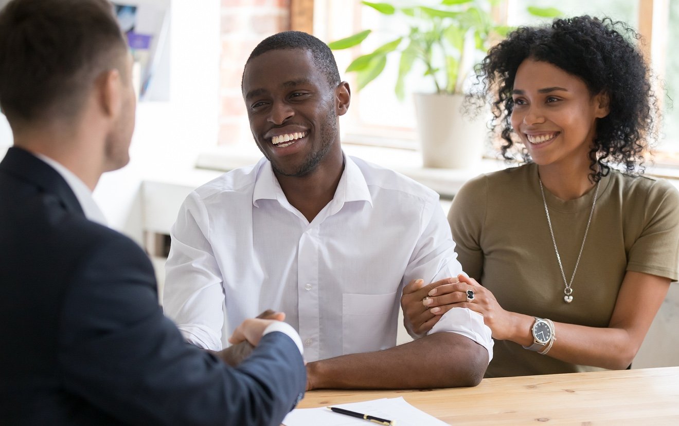Happy Black Couple Handshaking Realtor Insurer Landlord At Meeting