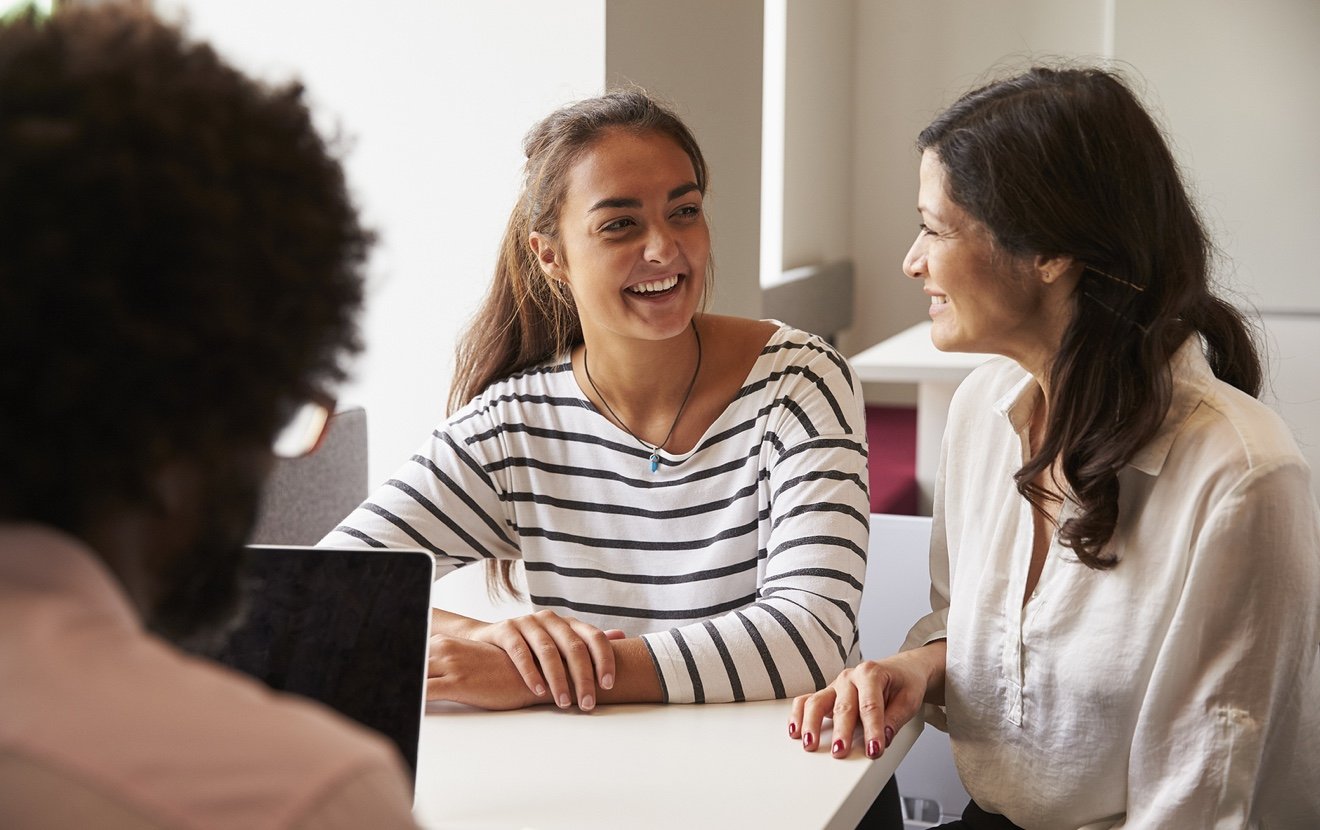 Mother And Daughter Meeting With Male Teacher