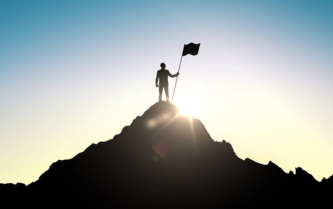 business, success, leadership, achievement and people concept – silhouette of businessman with flag