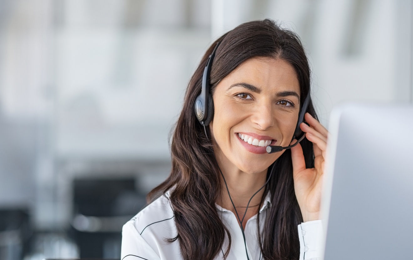 Call center agent with headset working on support hotline in modern office with copy space. Portrait