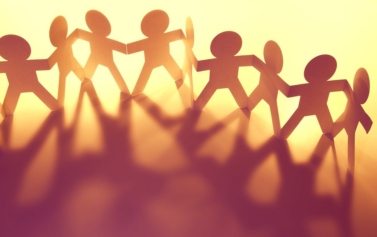 Team of paper doll people holding hands